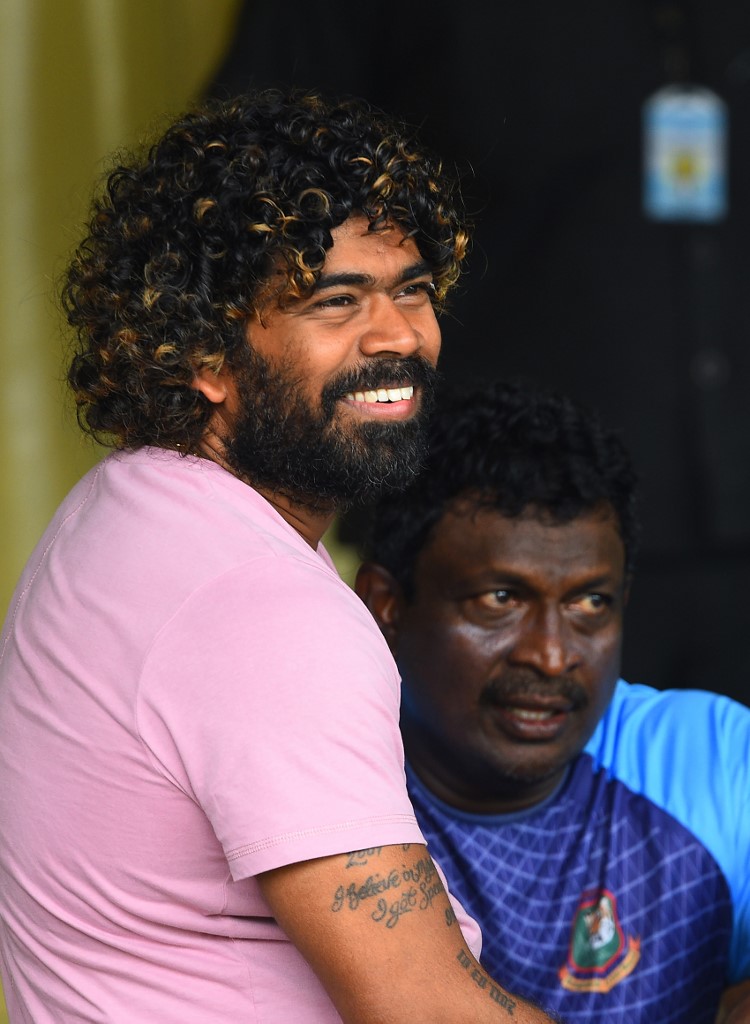 Sri Lankan cricketer Lasith Malinga (L) and Bangladesh bowling coach Champaka Ramanayake (R) look on during the one-day warm-up match between Sri Lanka Board President's XI and Bangladesh at the P. Sara Oval International cricket stadium in Colombo on July 23, 2019. - Veteran Sri Lankan pace bowler Lasith Malinga will retire from one-day international cricket with the first match of a three-match series against Bangladesh, skipper Dimuth Karunaratne said on July 22. (Photo by ISHARA S. KODIKARA / AFP)