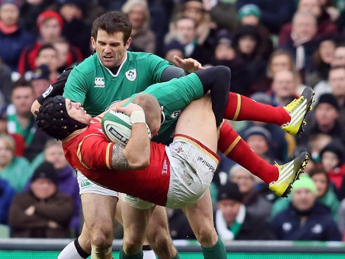 RUGBYU-6NATIONS-IRL-WAL Wales' wing Tom James (C) is tackled by Ireland's wing Keith Earls during the Six Nations international rugby union match between Ireland and Wales at the Aviva Stadium in Dublin, Ireland, on February 7, 2016. / AFP / PAUL FAITH