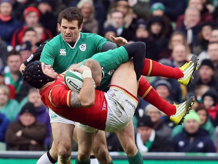 Wales' wing Tom James (C) is tackled by Ireland's wing Keith Earls during the Six Nations international rugby union match between Ireland and Wales at the Aviva Stadium in Dublin, Ireland, on February 7, 2016. / AFP / PAUL FAITH