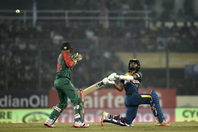Sri Lanka's Dinesh Chandimal (R) plays a shot next to Bangladesh's wicketkeeper Nurul Hasan (L) during the Asia Cup T20 cricket tournament match between Bangladesh and Sri Lanka at the Sher-e-Bangla National Cricket Stadium in Dhaka on February 28, 2016. / AFP / MUNIR UZ ZAMAN