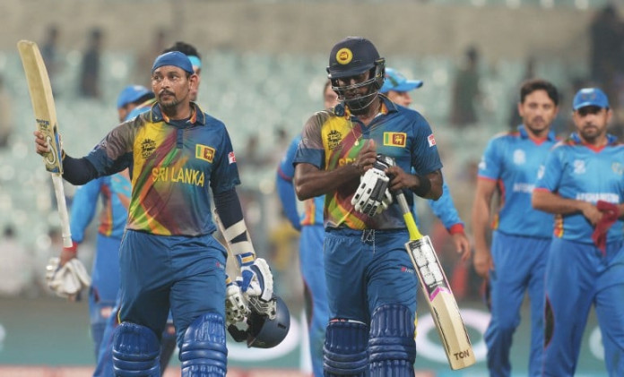Sri Lanka's Tillakaratne Dilshan raises the bat to celebrate the team's win after the World T20 cricket tournament match between Afghanistan and Sri Lanka at the Eden Gardens in Kolkata on March 17, 2016. / AFP / Dibyangshu SARKAR