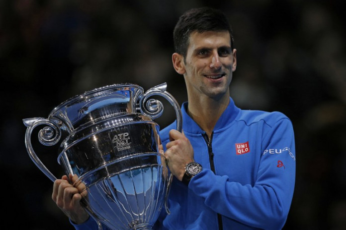 Serbia's Novak Djokovic holds the trophy of the ATP World No 1 Award after it was presented to him following his men's singles group stage match against Japan's Kei Nishikori