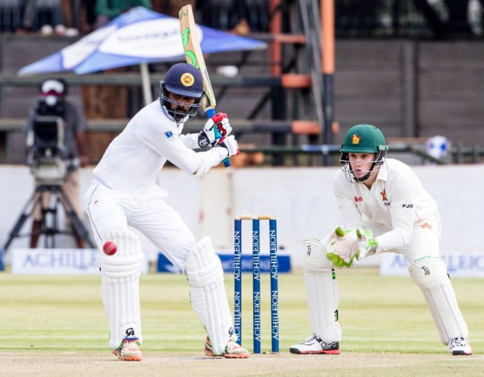 Sri Lanka batsman Upul Tharanga is in action as Peter Moor looks on during the second day's play in the first Test match between Sri Lanka and hosts Zimbabwe at the Harare Sports Club, on October 30, 2016. / AFP PHOTO / Jekesai Njikizana