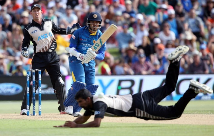 CRICKET-NZL-SRI Milinda Siriwardana of Sri Lanka (C) plays a shot past Ish Sodhi of New Zealand (bottom) as Luke Ronchi (L) of New Zealand looks on, during the first Twenty20 cricket match between New Zealand and Sri Lanka at the Bay Oval in Mount Maunganui on January 7, 2016. AFP PHOTO / MICHAEL BRADLEY / AFP / MICHAEL BRADLEY