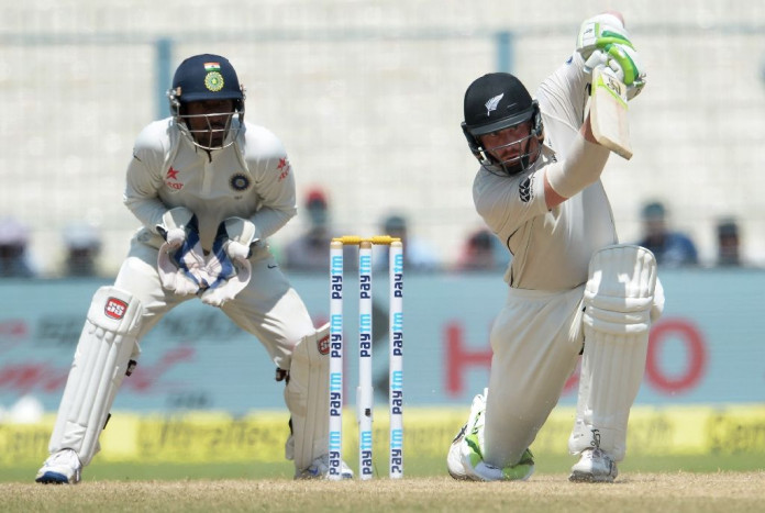 New Zealand's Martin Guptill plays a shot as India's wicketkeeper Wriddhiman Saha looks on during the fourth day of the second Test in Kolkata on October 3, 2016 (AFP Photo/Dibyangshu Sarkar)