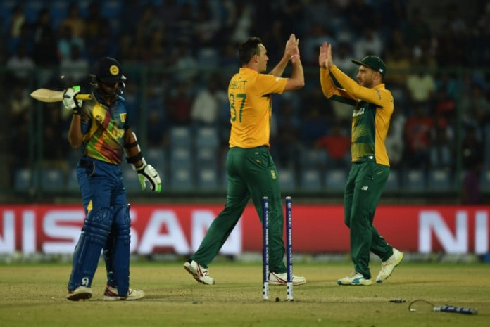 South Africa's Kyle Abbott(C)celebrates the wicket of Sri Lanka's batsman Jeffrey Vandersay(C) with captain Faf du Plessis during the World T20 cricket tournament match between South Africa and Sri Lanka at The Feroz Shah Kotla Cricket Ground in New Delhi on March 28, 2016. / AFP / PRAKASH SINGH