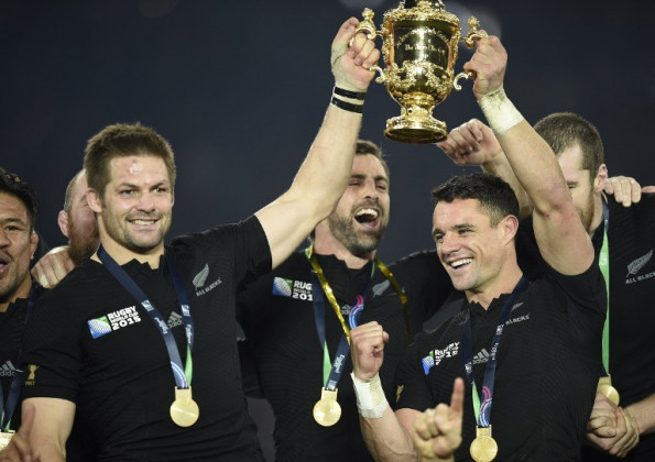 New Zealand's flanker and captain Richie McCaw (L) holds the Webb Ellis Cup next to New Zealand's fly half Dan Carter as they celebrate with teammates after winninng the RWC final ©AFP