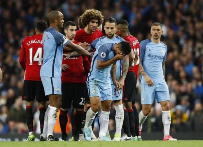 Manchester United's Marouane Fellaini with Manchester City's Sergio Aguero after being sent off by referee Martin Atkinson